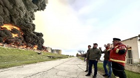 This handout photograph released by the Government of Sevastopol on April 29, 2023, shows firefighters looking at a burning fuel depot in Sevastopol as a drone hit a Crimea fuel depot overnight. - A huge fire broke out on Saturday at a fuel depot in
