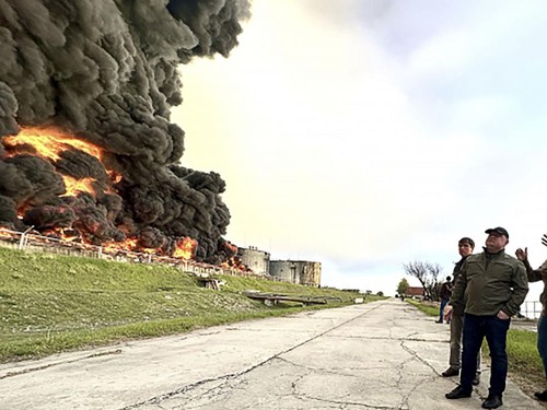 This handout photograph released by the Government of Sevastopol on April 29, 2023, shows firefighters looking at a burning fuel depot in Sevastopol as a drone hit a Crimea fuel depot overnight. - A huge fire broke out on Saturday at a fuel depot in