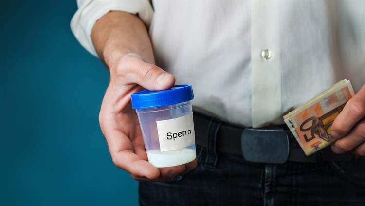 Money and container with sperm in hands of man. Concept of donating sperm