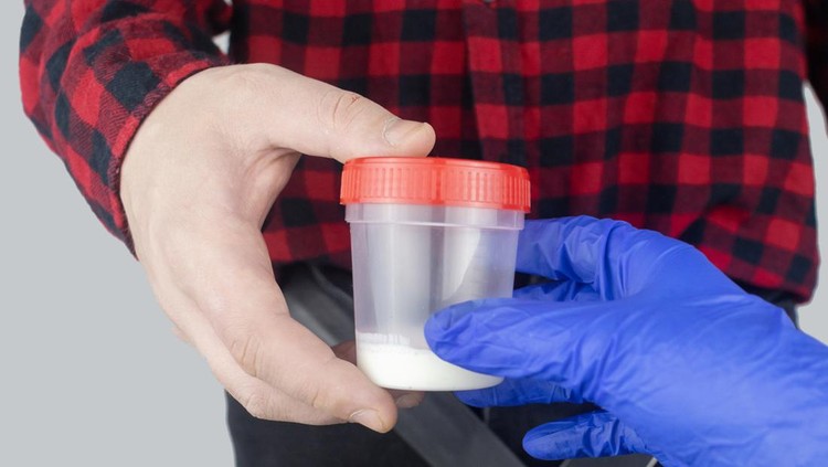 Money and container with sperm in hands of man. Concept of donating sperm