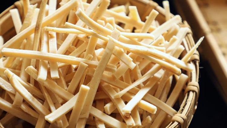 Kerupuk Stik Bawang. Stick cracker of garlic and tapioca paste that's shaped into thin sticks. The cracker is placed in a woven bamboo container and arranged among other crackers.