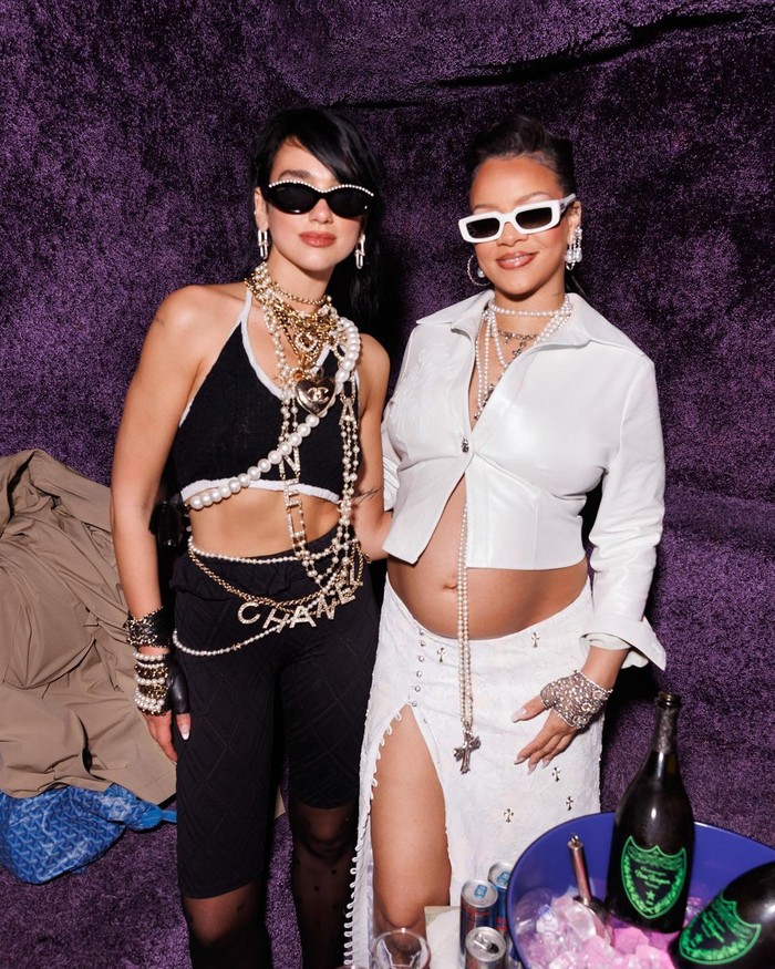 Dua Lipa dan Rihanna foto bersama dalam outfit black & white yang kontras, Beauties! Dua dengan outfit Chanel berhias layer aksesori dan Rihanna berbalut setelan kreasi Chrome Hearts.