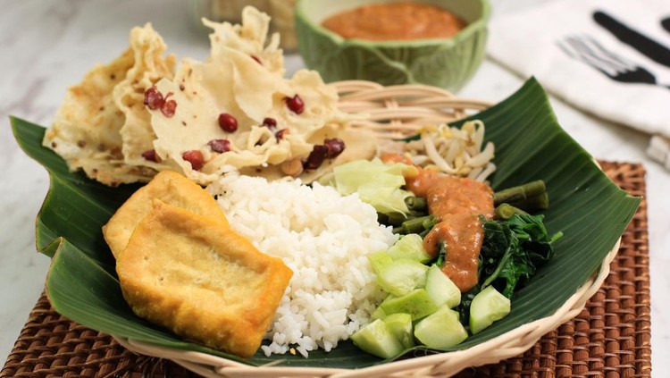 1335321174 Nasi Pecel. Traditional Javanese Rice Dish of Steamed Rice with Vegetable Salad, Peanut Sauce Dressing, Tempeh, Tofu Beancurd, and Peyek Crackers. Pecel Madiun is Most Popular Variant