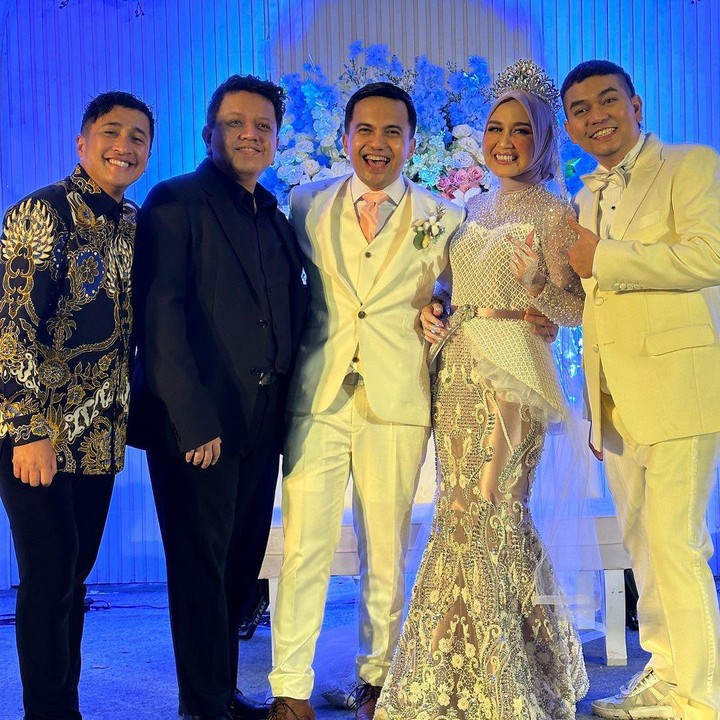 <p>Pria 46 tahun ini mengenakan setelan jas putih lengkap dengan dasi merah muda. Sementara itu, sang istri nampak anggun dengan gaun warna senada. (Foto: Instagram: @irfanhakim75)</p>