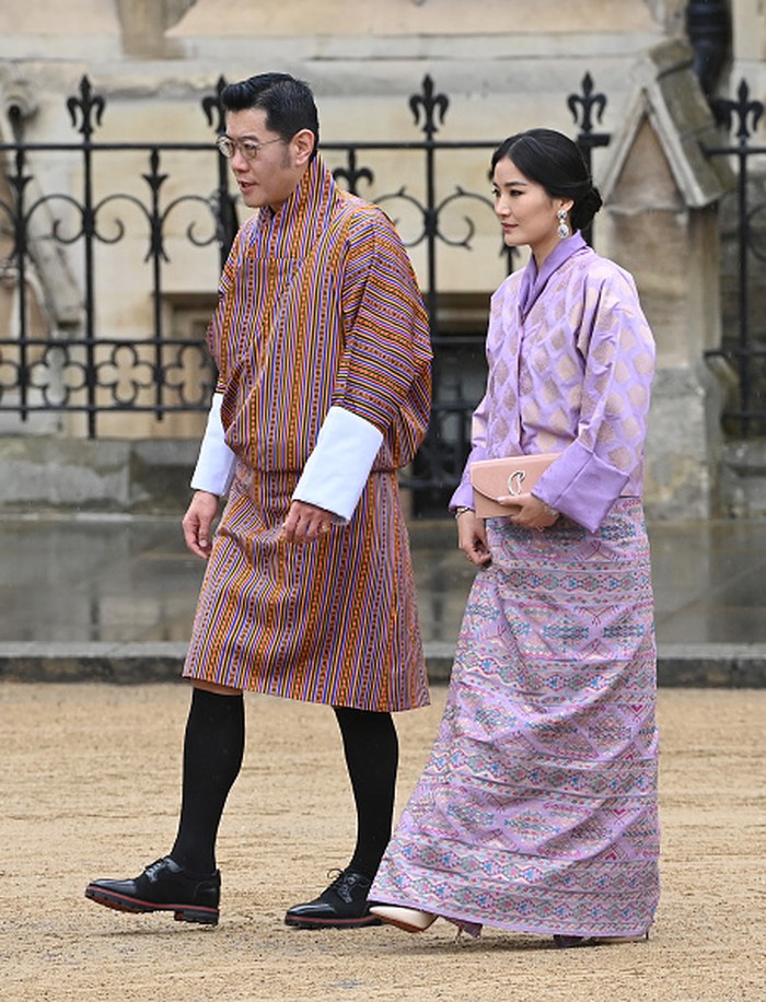 Pakaian tradisional Bhutan selalu jadi pilihan Raja Jigme dan Ratu Jetsun Pema. Sang Ratu terlihat memadukan busana warna lilac dengan clutch dan statement earrings.Foto: Getty Images/Stuart C. Wilson