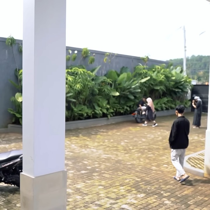 <p>Sementara itu, halaman belakang rumah Rossa juga terlihat luas. Tempat ini digunakan sebagai lahan parkir. Terdapat beberapa jenis tanaman hijau untuk memberi kesan asri. (Foto: YouTube Rossa Official)</p>