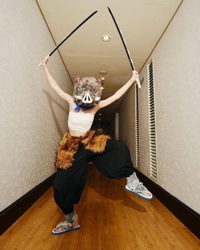 Penasaran siapa yang ada di balik topeng ini? Ya, Yuki Kato berdandan menjadi tokoh Inosuke dari kartun Demon Slayer. Sandal jepit yang dipakainya sukses bikin netizen salah fokus! Foto: instagram.com/yukikt