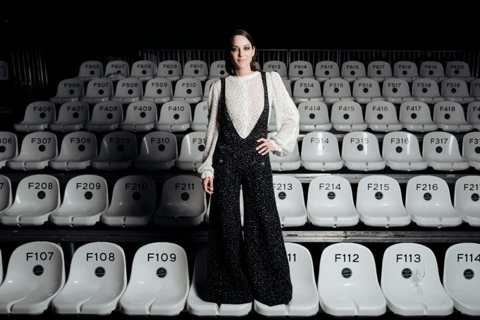 Marion Cotillard memilih kombinasi jumpsuit berpotongan V-neck dan blus putih. Miniamalist but with '70s flaire. Foto: Courtesy of Chanel