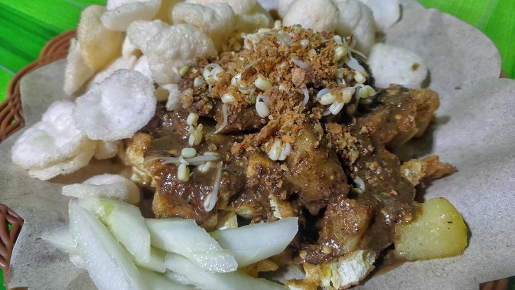 Tahu Tek is Indonesian food, it contains fried egg,  fried tofu,  fried potato, bean sprouts,  cucumber, crackers and peanut sauce.  the sauce,  it can be mixed with chilies.