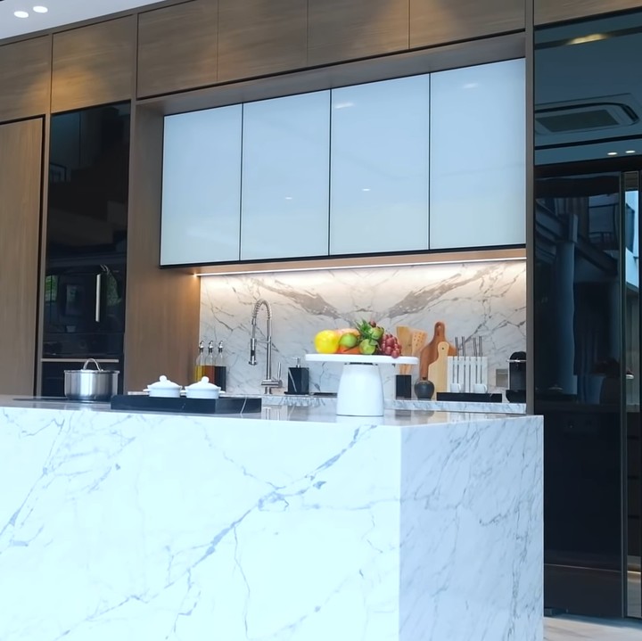 <p>Tak kalah menarik, marmer yang melapisi sebagian besar ruangan dapur Titi dan Tian dibuat secara khusus, lho. "Marmer ini benar-benar spesial. Ini memang dipasang sangat <em>perfect</em>, terlihat seperti sebongkah batu utuh padahal enggak. Di belakang <em>island</em> juga ada berbagai macam laci dan stop kontak," bebernya. (Foto: YouTube Titi dan Tian)</p>