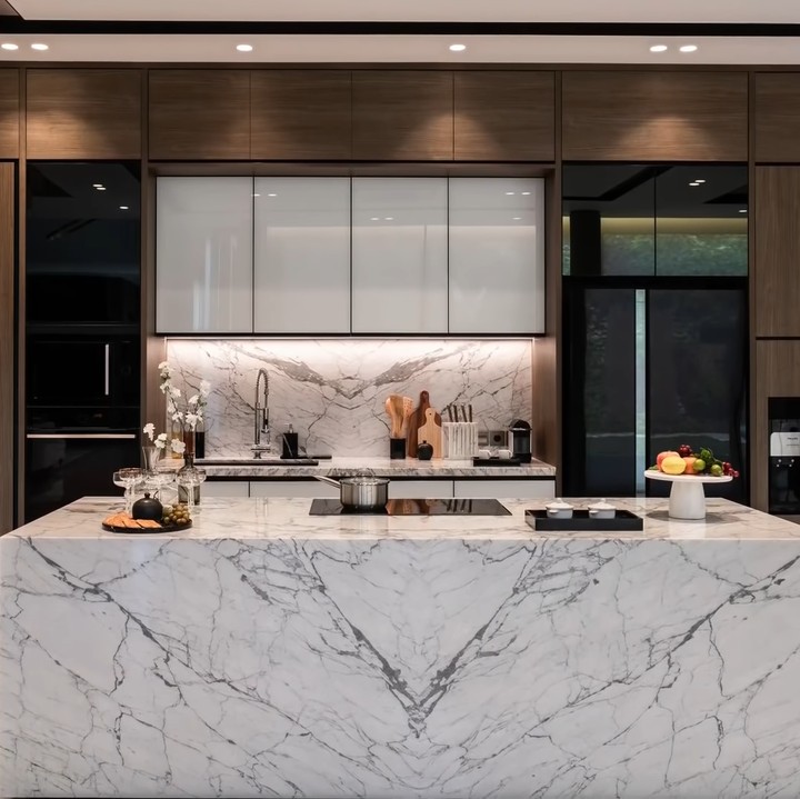 <p>Dapur Titi Kamal dilengkapi dengan berbagai macam peralatan canggih. Island counter yang mereka gunakan untuk memasak dilapisi oleh marmer untuk memberi kesan mewah dan elegan. (Foto: YouTube Titi dan Tian)</p>