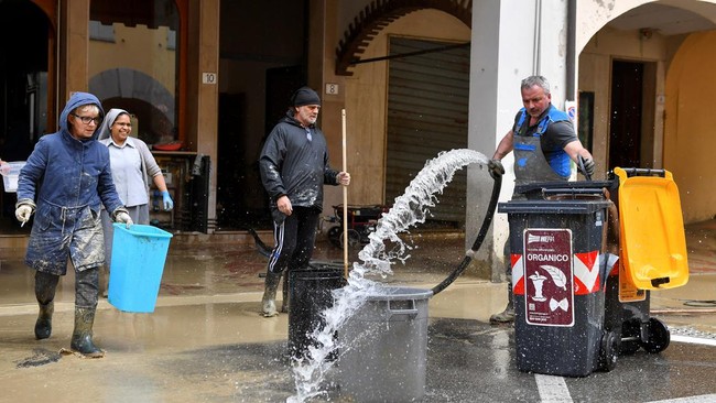 FOTO: Warga Italia Bersih-bersih Lumpur Usai Diterjang Banjir Bandang