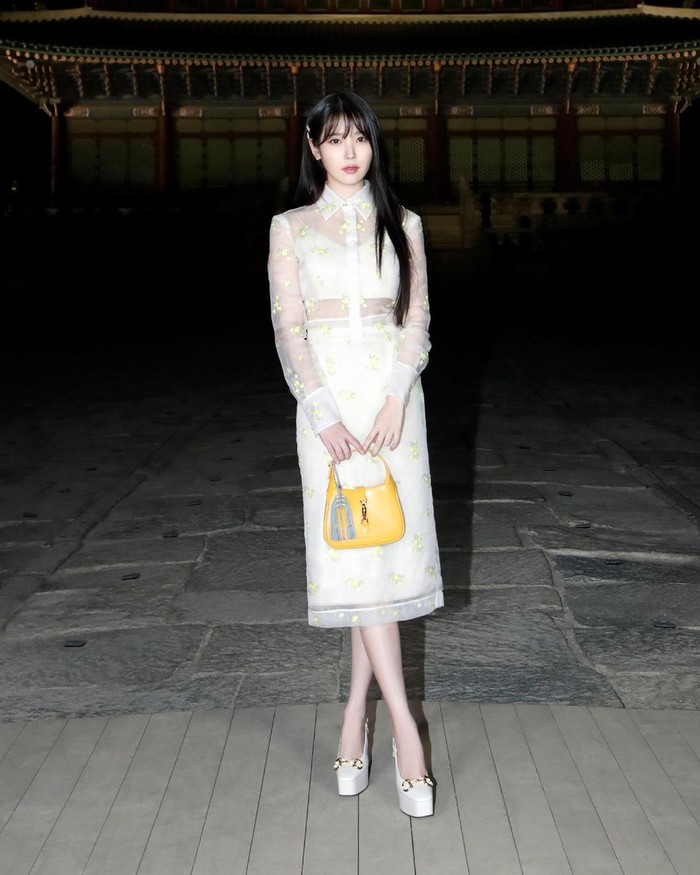 Kombinasi blus, rok, dan sepatu serba putih jadi terlihat lebih playful berkat pilihan tas warna kuning seperti ditampilkan oleh IU. Foto: Instagram Gucci