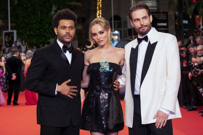 Diapit lawan mainnya The Weekend dan Sam Levinson selaku sutradara, Lily-Rose Depp tampil stylish di premier mengenakan gaun pendek vintage Chanel dari tahun 1994. Foto: WireImage/Samir Hussein