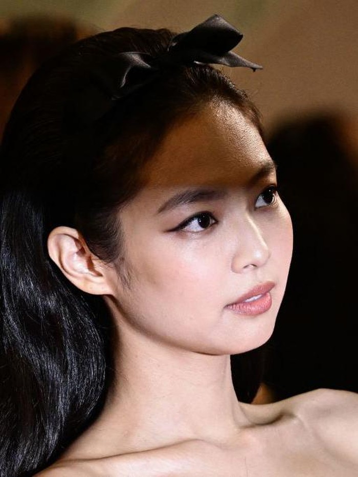 Dalam salah satu potret close-up, Jennie terlihat memancarkan kecantikan alami dengan riasan natural, dengan sentuhan wing eye-liner./ Foto: AFP via Getty Images/LOIC VENANCE