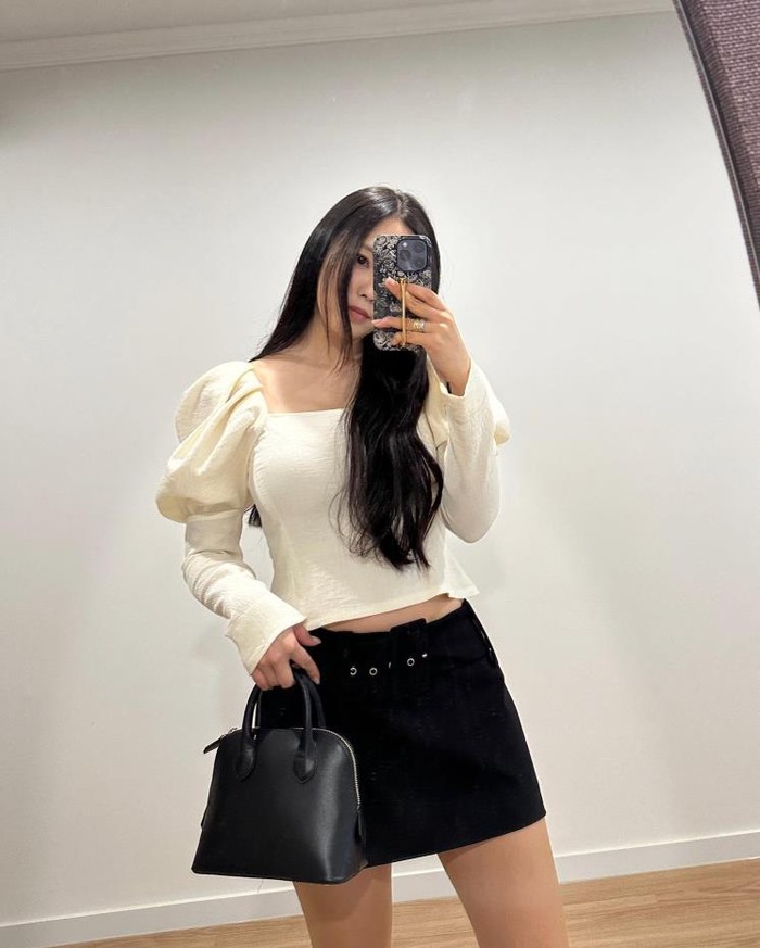 Hyomin memakai blouse dengan style menonjolkan bahu yang membuatnya terlihat elegan. Untuk menambah pesona blouse yang feminin, Hyomin menyempurnakannya dengan rok dan tas berwarna hitam./ Foto: instagram.com/hyominnn