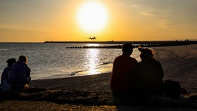 FOTO: Panorama Pesawat Mendarat Berlatar Senja di Pantai Kelan Bali