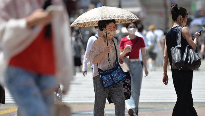Seorang lansia berjalan di jalan menggunakan payung untuk melindungi dirinya dari sinar matahari pada 27 Juni 2022, di distrik Shibuya yang populer di Tokyo, Tokyo, Jepang. (File Foto - David Mareuil/Anadolu Agency via Getty Images)