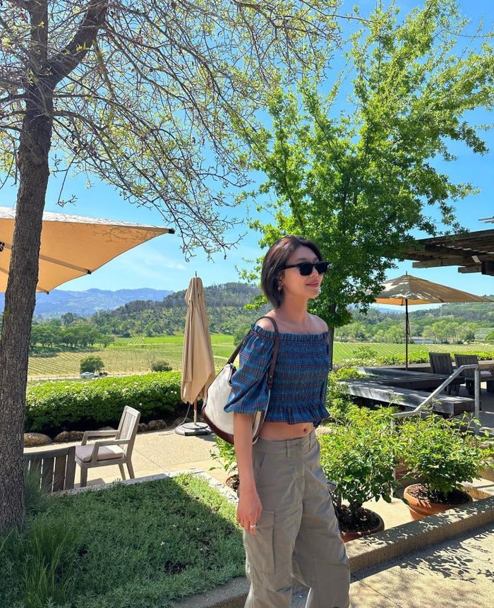 Sooyoung memilih blouse off-shoulder dengan pola yang kalem. Detail smoked frills di finishing dengan cropped design membuat body line-nya terlihat slim. Sense of matching cargo pants juga memberikan kesan stylish./ Foto: intagram.com/sooyoungchoi