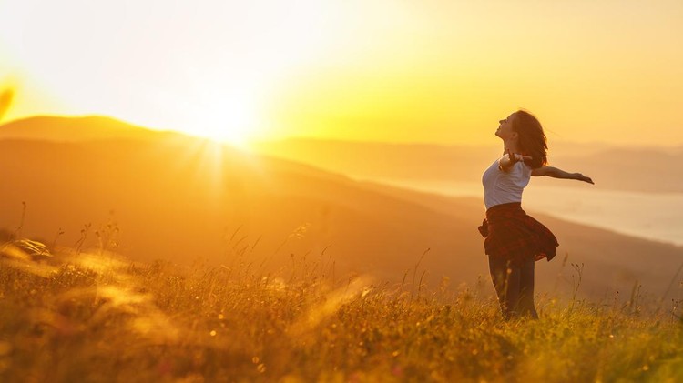 927402888 Happy woman on the sunset in nature in summer with open hands