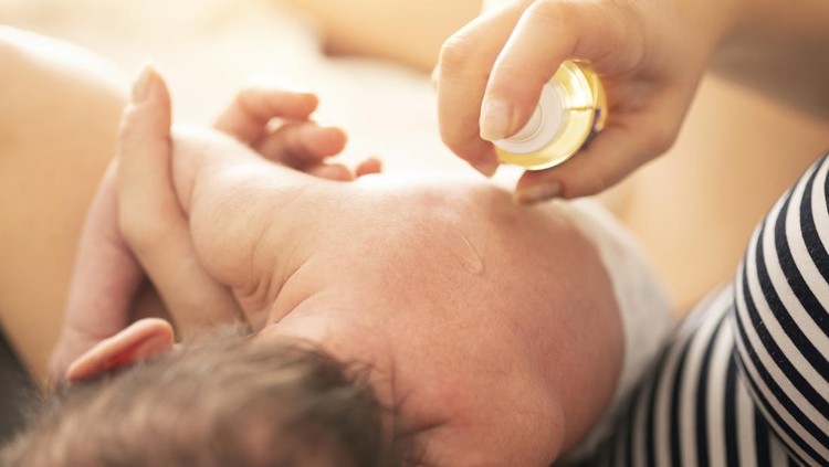 Mother makes massage with baby oil