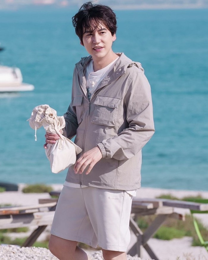 Aura Kyuhyun semakin bersinar dengan angin lembut Dubai yang menerpa rambutnya dan memperlihatkan visual menawannya. Member Super Junior tersebut berdiri membelakangi lautan biru sambil memegang sebuah karung bersikan benda misterius./ Foto: soompi.com