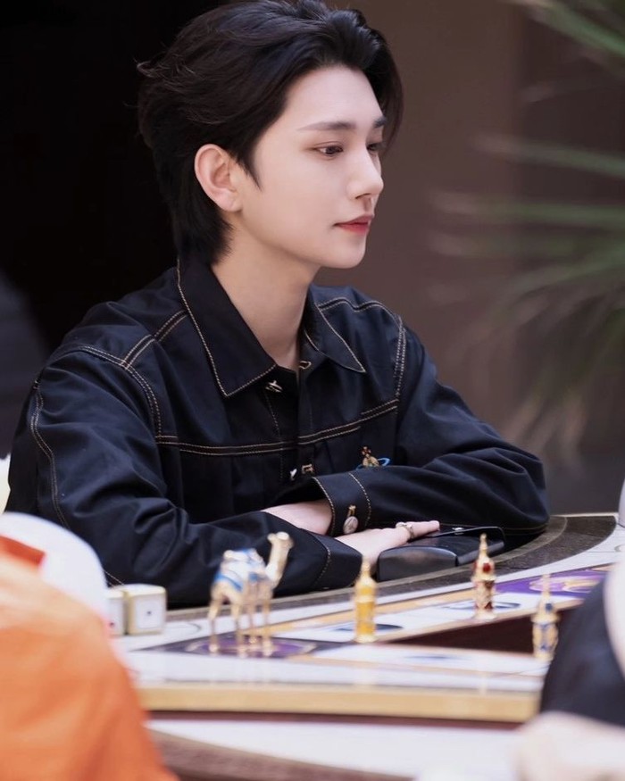 Blue Marble merupakan permainan papan khas Korea Selatan yang cara bermainnya menyerupai Monopoli. Papan tersebut terlihat jelas di hadapan tempat Joshua SEVENTEEN duduk dan memancarkan visual candid memesona dalam balutan kemeja hitam./ Foto: soompi.com