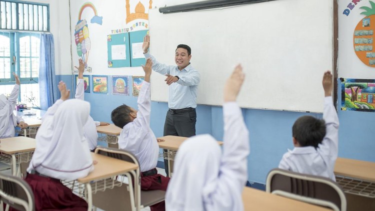 Students raise their hands to answer questions in class.
