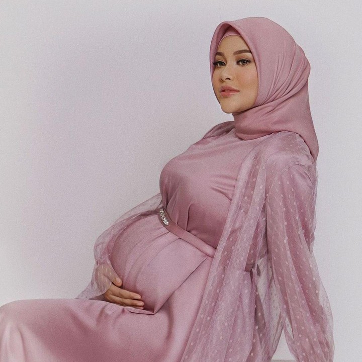 <p>Aurel fokus memamerkan <em>baby bump</em> saat <em>maternity shoot</em> kehamilan pertama. Wanita 24 tahun ini terlihat anggun mengenakan gaun berwarna merah muda, senada dengan hijabnya. (Foto: Instagram @aurelie.hermansyah)</p>