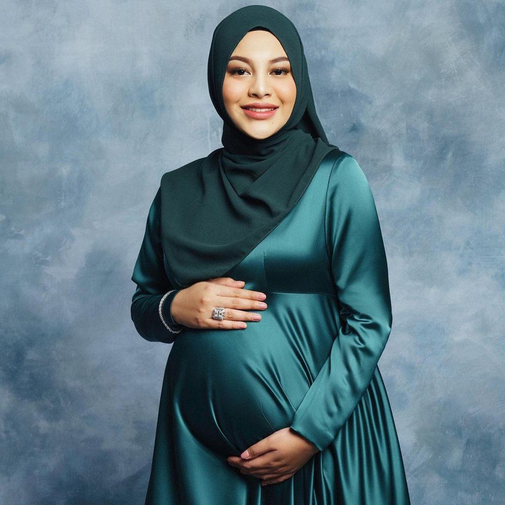 <p>Aurel memamerkan baby bump kehamilan pertamanya dengan konsep foto yang sederhana. Istri Atta Halilintar ini foto di studio dengan latar berwarna biru putih,. Aurel mengenakan gaun berwarna hijau, senada dengan jilbabnya. (Foto: Instagram @aurelie.hermansyah)</p>