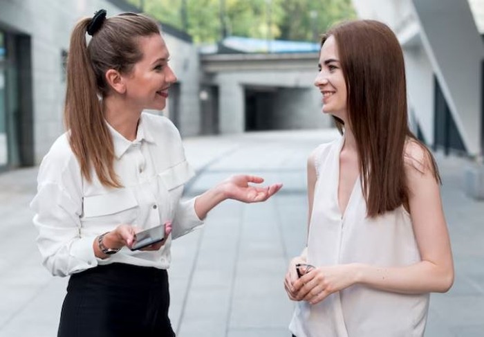 Dua perempuan sedang mengobrol
