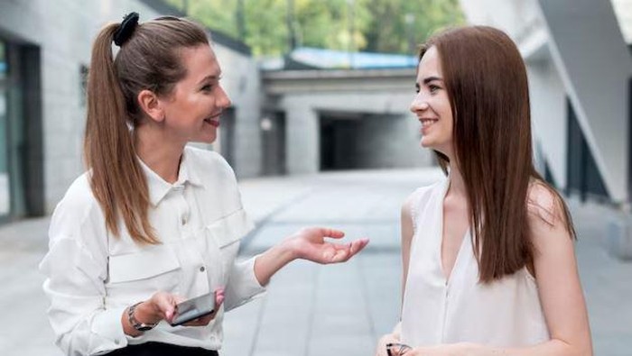 Dua perempuan sedang mengobrol