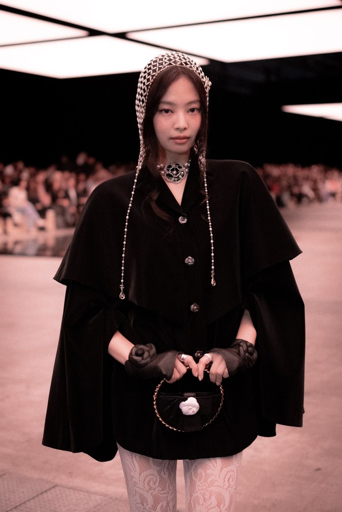 Jennie tampilkan gaya elegan dan retro glamor lewat padanan cape dress hitam dengan aksesori berypa beanie kristal dan sarung tangan. Foto: Courtesy of Chanel