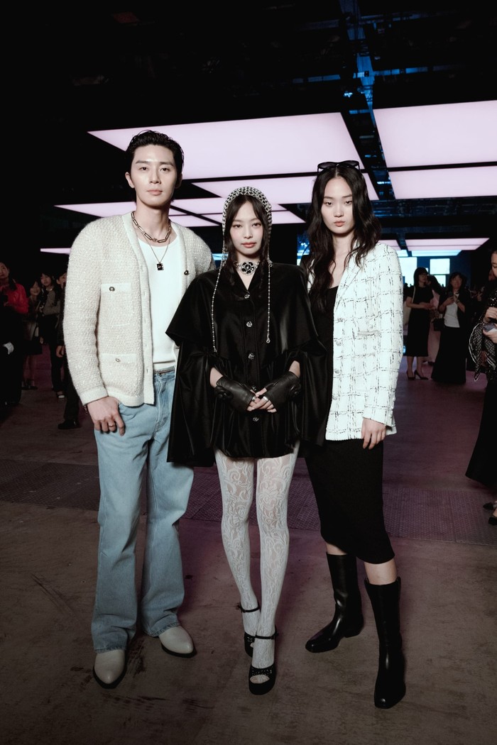 Park Seo Joon dan Jennie berfoto bersama model Korsel Hyunji Shin yang bergaya quirky lewat padanan dress hitam bersama jaket tweed dan boots tinggi.Foto: Courtesy of Chanel