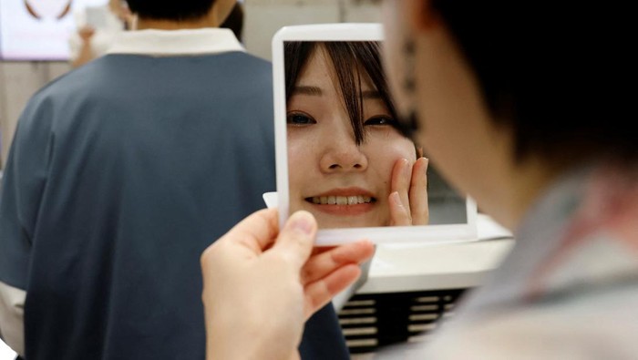 Students learn how to practice facial muscles with mirrors at a smile training course at Sokei Art School in Tokyo, Japan, May 30, 2023. REUTERS/Kim Kyung-Hoon     TPX IMAGES OF THE DAY