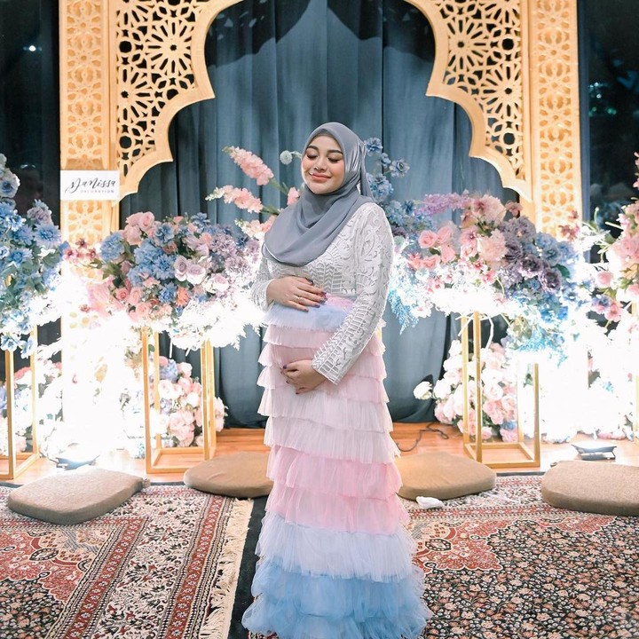 <p>Dalam unggahan ini, Aurel tampak anggun mengenakan gaun berwarna mix putih, merah muda, dan biru muda. Penampilannya semakin glowing dengan hijab berwarna abu-abu. (Foto: Instagram @aurelie.hermansyah)</p>