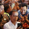Indonesian President Joko Widodo takes a selfie with the crowd during a visit to a wet market, amid the president's working visit to the country, in Kuala Lumpur, Malaysia June 8, 2023. REUTERS/Hasnoor Hussain