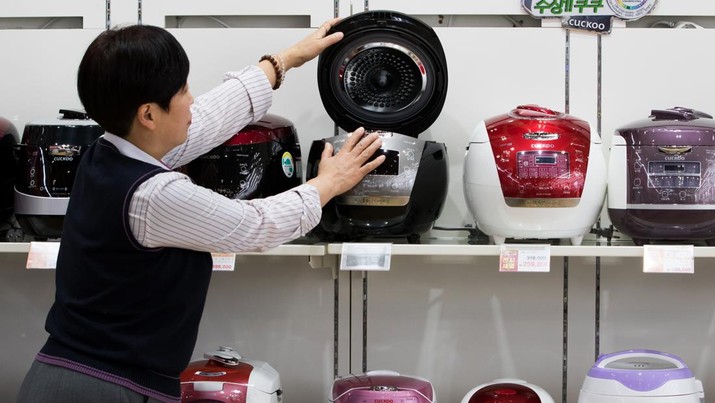 An LG Electronics Inc. employee inspects a Cuckoo Electronics Co. rice cooker at the LG Bestshop store in Seoul, South Korea, on Friday, Jan. 22, 2016. LG Electronics is scheduled to release fourth quarter results on Jan. 26. Photographer: SeongJoon Cho/Bloomberg via Getty Images