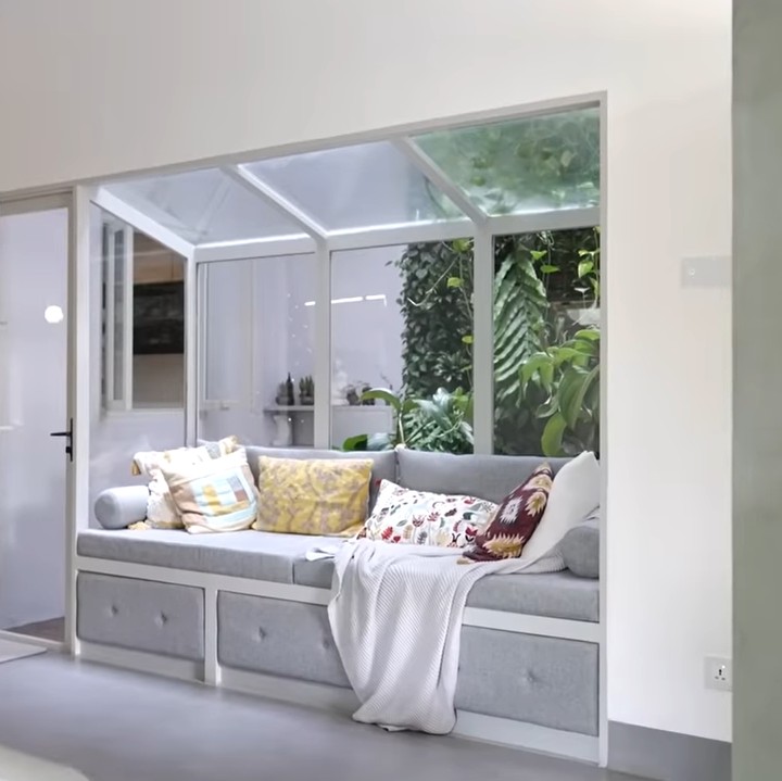 <p>Di sebelah tangga, terdapat sofa malas di sudut ruangan yang bersebelahan dengan jendela. "Ini tempat gue nap time 10-15 menit. Enak banget belakangnya ada <em>vertical tropical garden</em> jadi kalau hujan mau malas-malasan di sini," ujar Sharena. (Foto: YouTube Sharena Delon - Party of Four)</p>