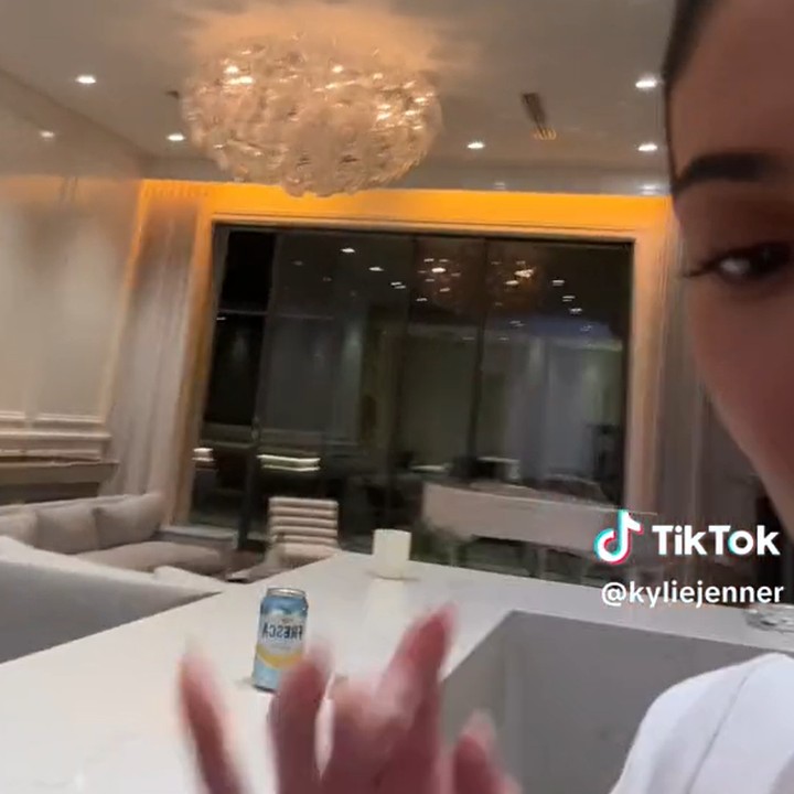 <p>Pada ruang tengah, Kylie memasang chandelier besar sebagai pusat penerangan. Lampu itu menerangi jajaran sofa panjang berwarna putih. (Foto: TikTok @kyliejenner)</p>