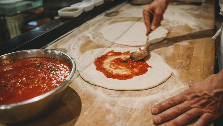Pizza chef preparing a pizza at the restaurant