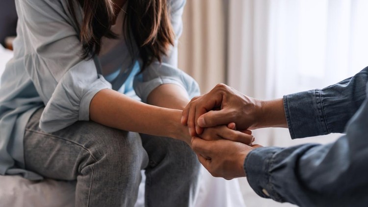Young man comforting and supporting a sad woman who is in serious trouble at home, Consolation and encouragement concept