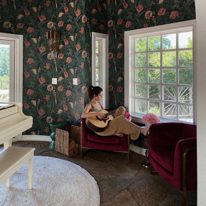 <p>Selain dapur, rumah Selena juga memiliki area santai yang dihiasi dengan wallpaper bernuansa bunga vintage. Di tempat ini, Selena banyak menghabiskan waktu saat menjalani karantina di masa pandemi<em>. "Things I’ve been doing in quarantine- settling into my new house and guitar lessons,"</em> ujarnya. (Foto: Instagram @selenagomez)</p>
