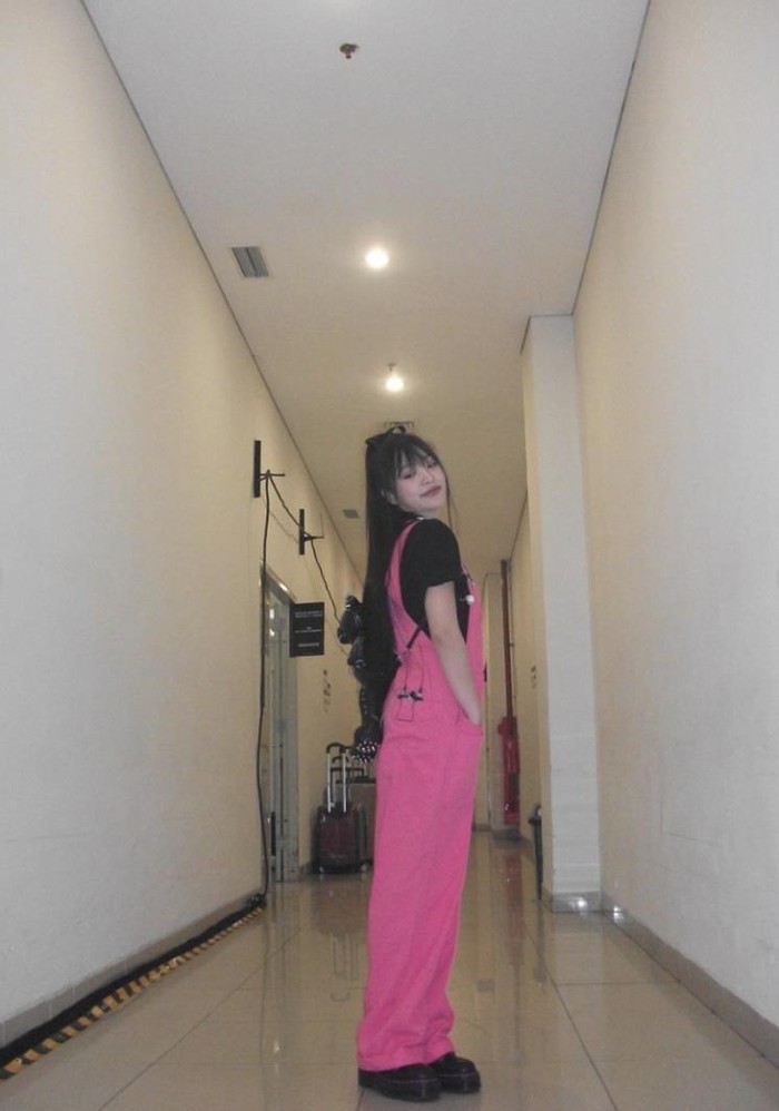 Yeri Red Velvet memancarkan pesona yang cute, imut, dan berbeda dengan overall jumpsuit berwarna pink fuchsia. Ia juga menambahkan pita ke rambutnya dan memadukan tampilannya dengan ransel boneka beruang kitsch. / Foto: Elle.co.kr