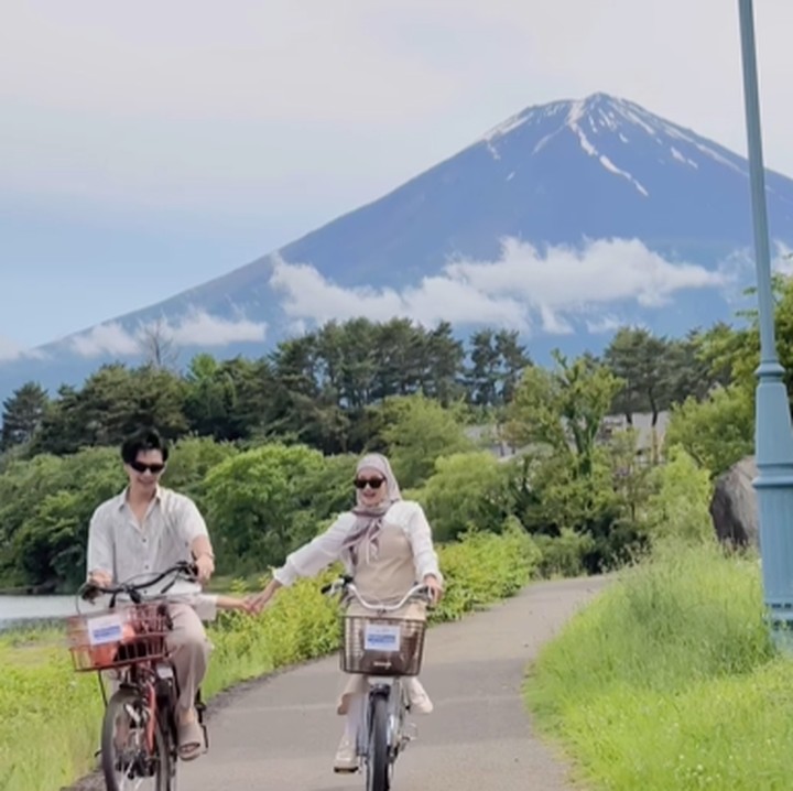 <p>Saat bersepeda menikmati keindahan gunung di Jepang, pasangan ini kembali memilih <em>outfit</em> bernuansa lembut untuk dikenakan. Mereka memakai busana <em>earthy tone</em> yang didominasi oleh warna putih dan <em>beige.</em> (Foto: Instagram @dindahw)</p>