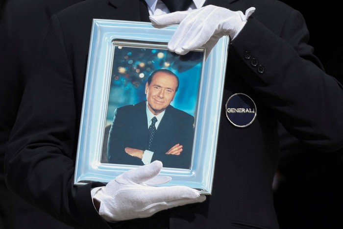 A pallbearer holds a portrait of former Italian Prime Minister Silvio Berlusconi while walking in front of the coffin during his state funeral at the Duomo Cathedral, in Milan, Italy June 14, 2023. REUTERS/Yara Nardi