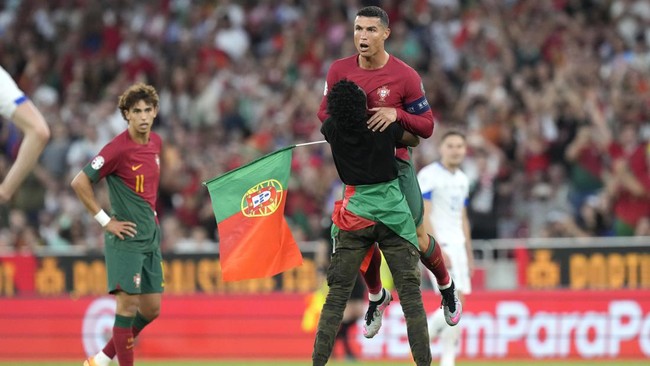 Seorang fans yang menyusup dalam laga Portugal vs Bosnia sujud di depan Cristiano Ronaldo, menggendong dan melakukan selebrasi 'siuu' bersama CR7.