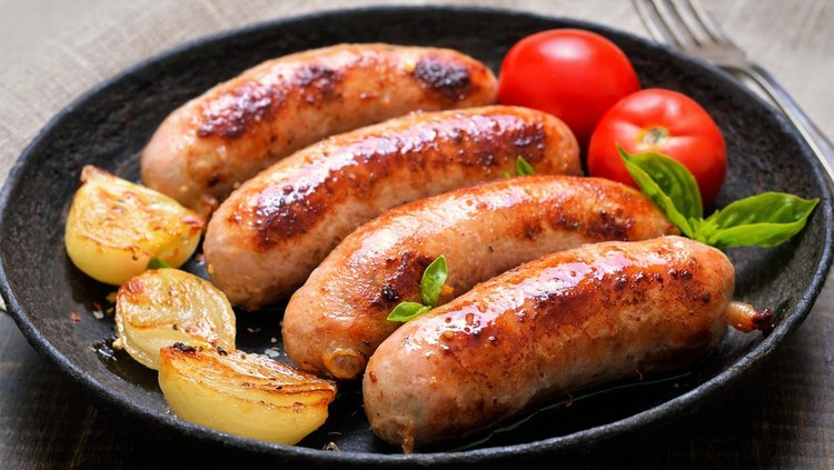 Grilled sausages and vegetables in frying pan, close up