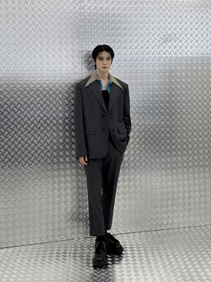 Idol-aktor kelahiran 1997 mengenakan outfit bergaya formal yang didominasi warna abu-abu, serta gaya rambut sleek hair yang menyempurnakan penampilannya./ Foto: twitter.com/NCTsmtown