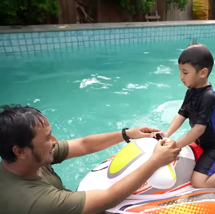 <p>Di kolam tersebut, Kiano menggunakan seluruh mainan dan pelampung yang ia miliki untuk sekadar bermain air hingga berenang. (Foto: YouTube Baim Paula)</p>